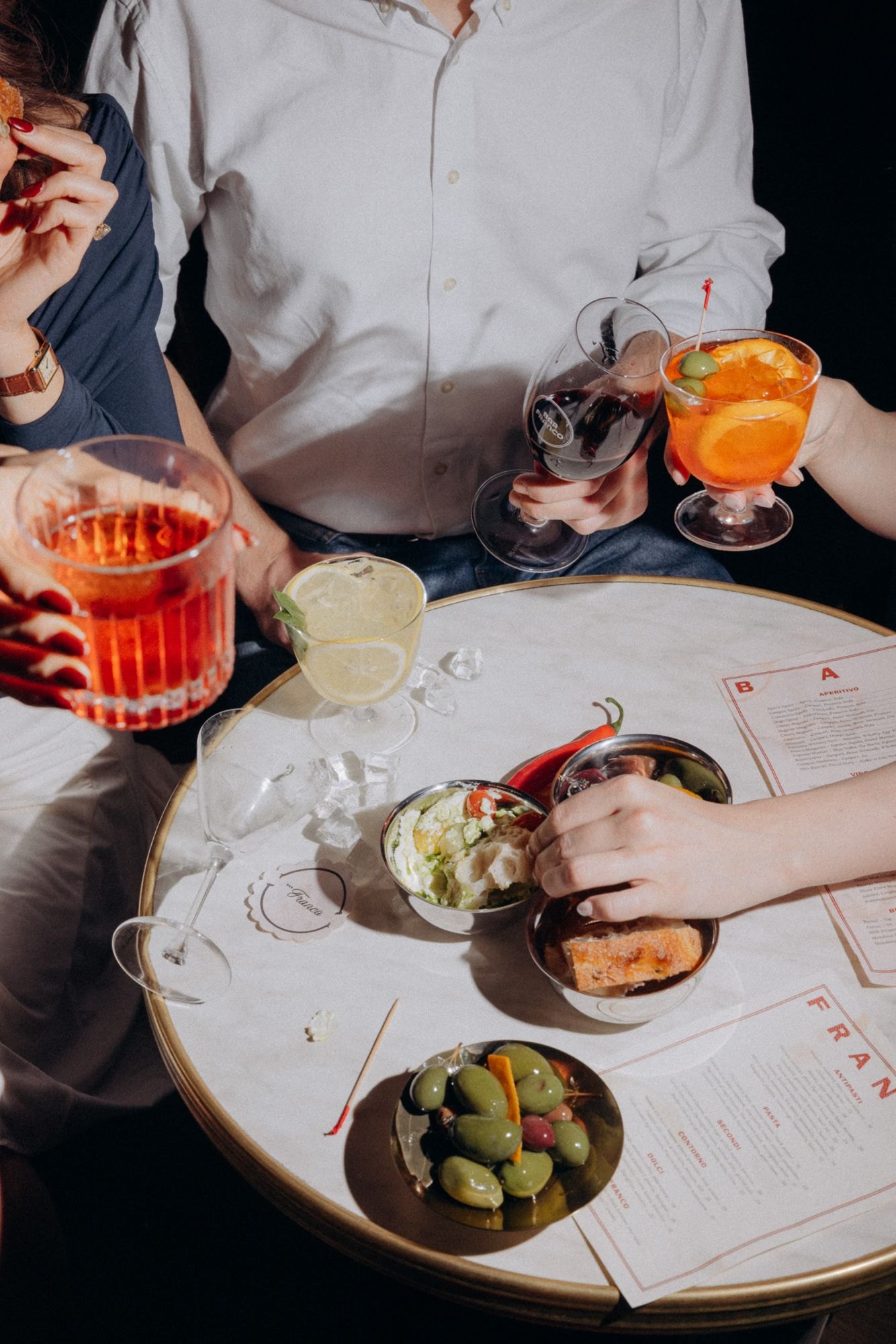 Negroni, spritz and antipasti on the marble table, the BAR and FRANCO menus beside them