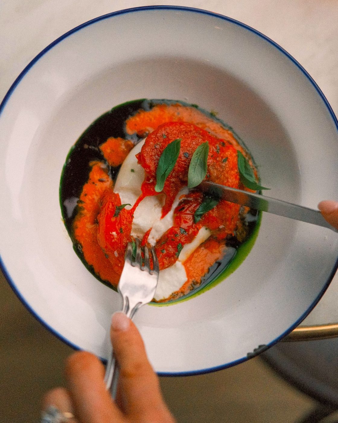 Burrata and tomatoes, a fork going in