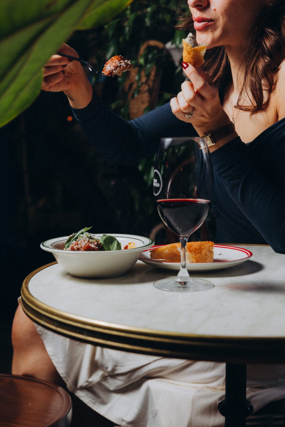 A guest enjoying pasta and red wine at Bar Franco