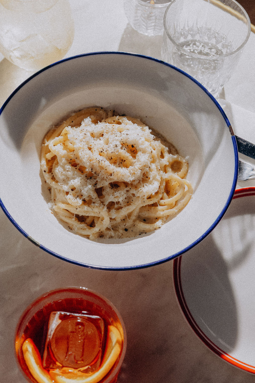 Fresh pasta and a spritz on the marble table, from above