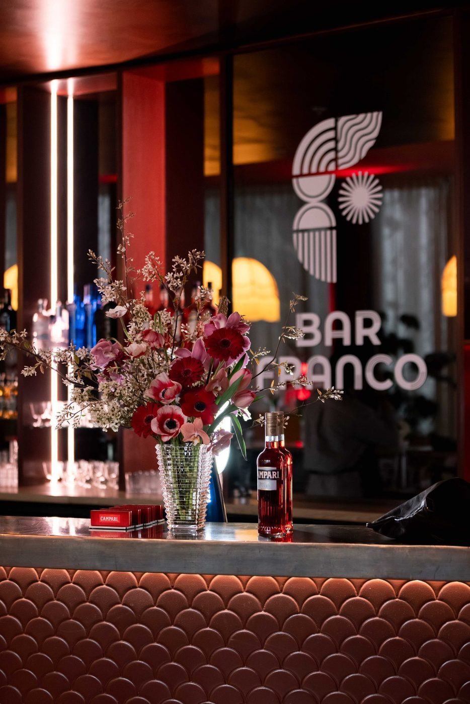 Flowers and a bottle of Campari on the bar, the Bar Franco sign behind