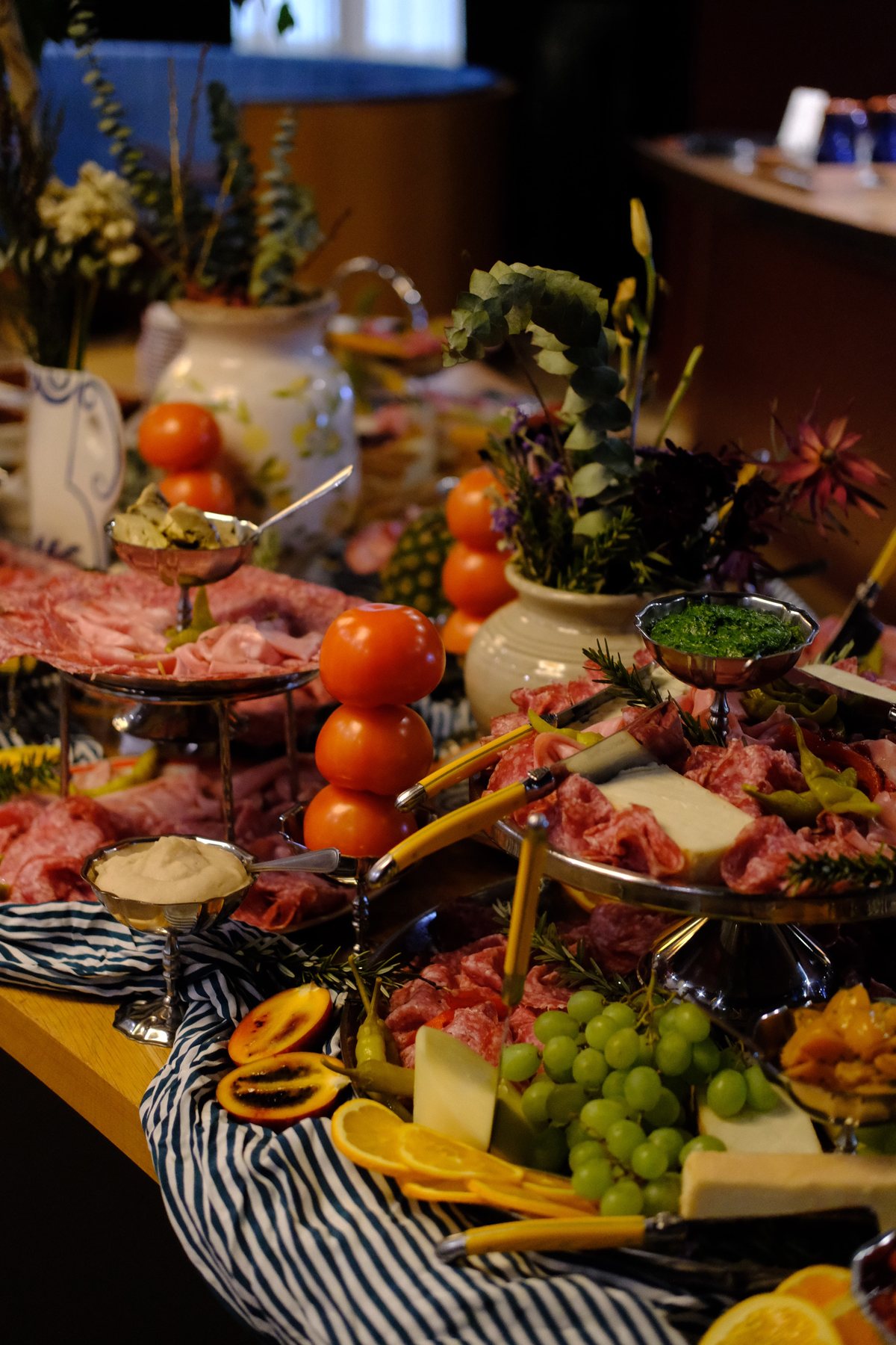 A grazing table of cured meats, cheeses, fruit and flowers
