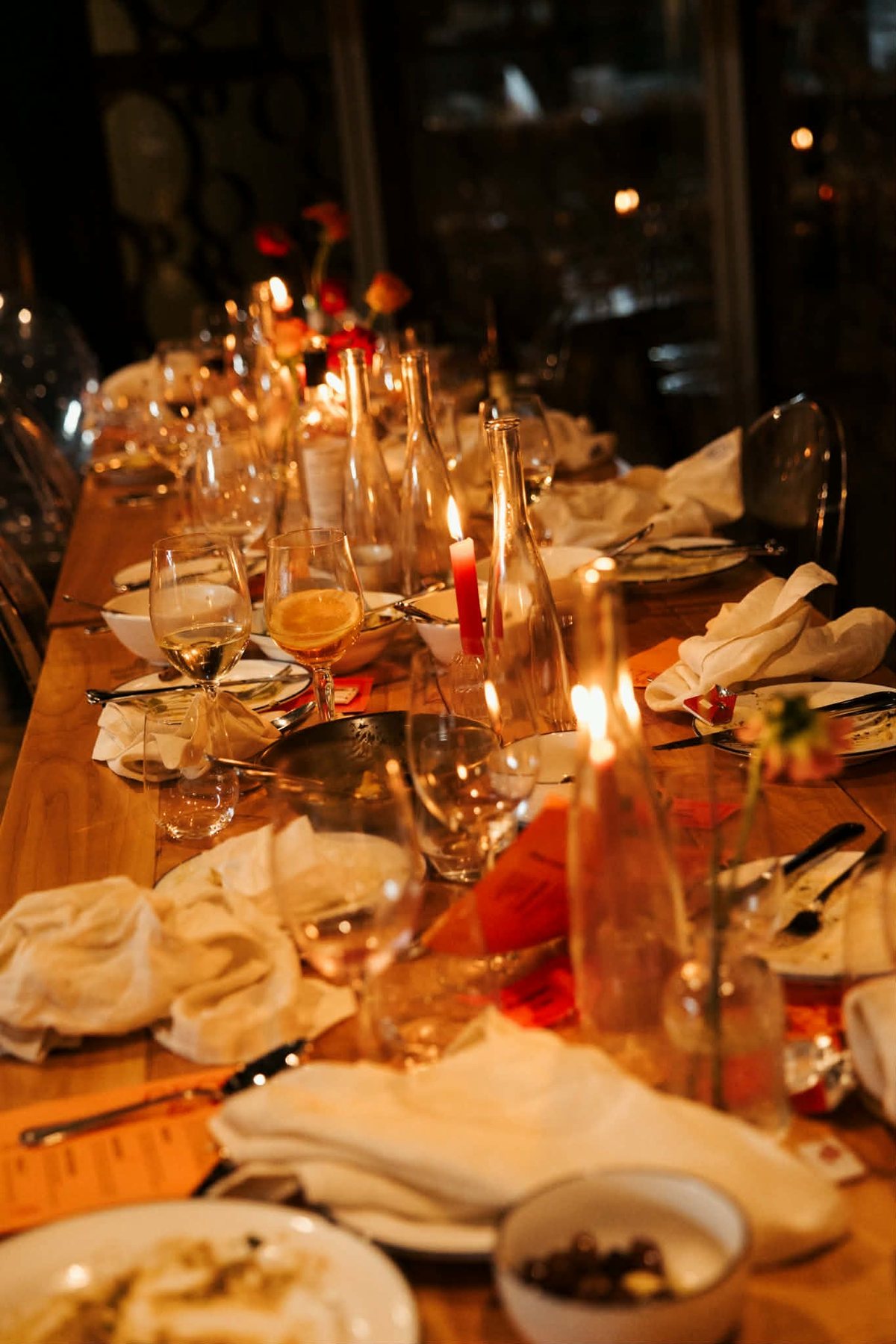 A long table at the end of the night, candles still burning