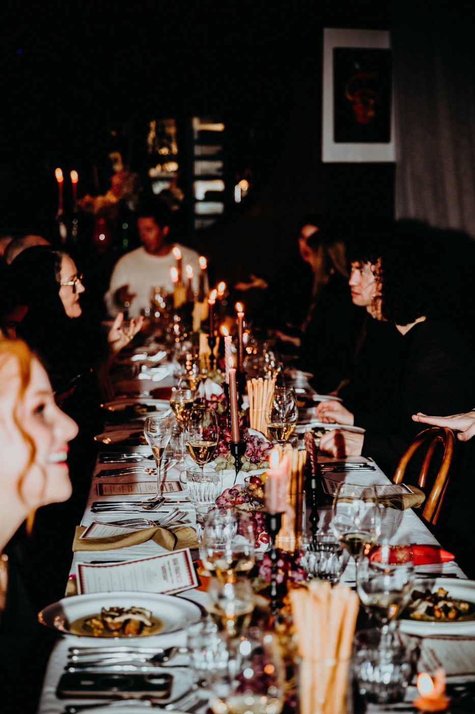 Plates of fresh pasta carried to a candlelit table