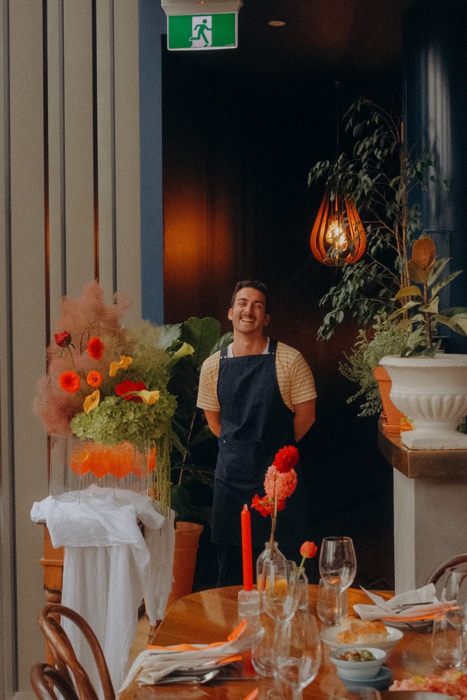 One of the team laughing beside a table set with flowers and candles