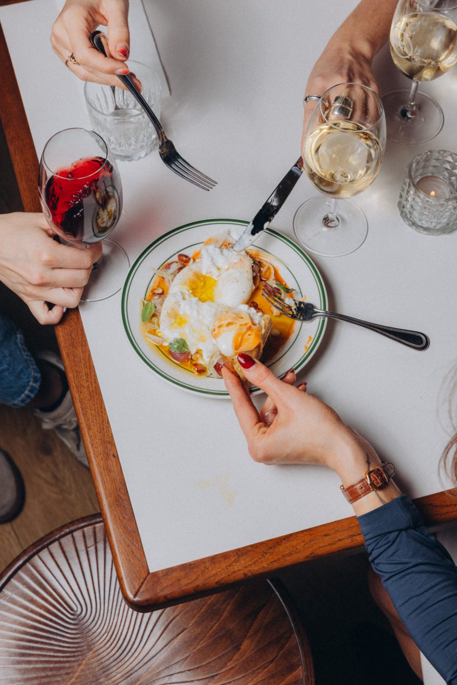 Friends sharing plates over wine at Bar Franco