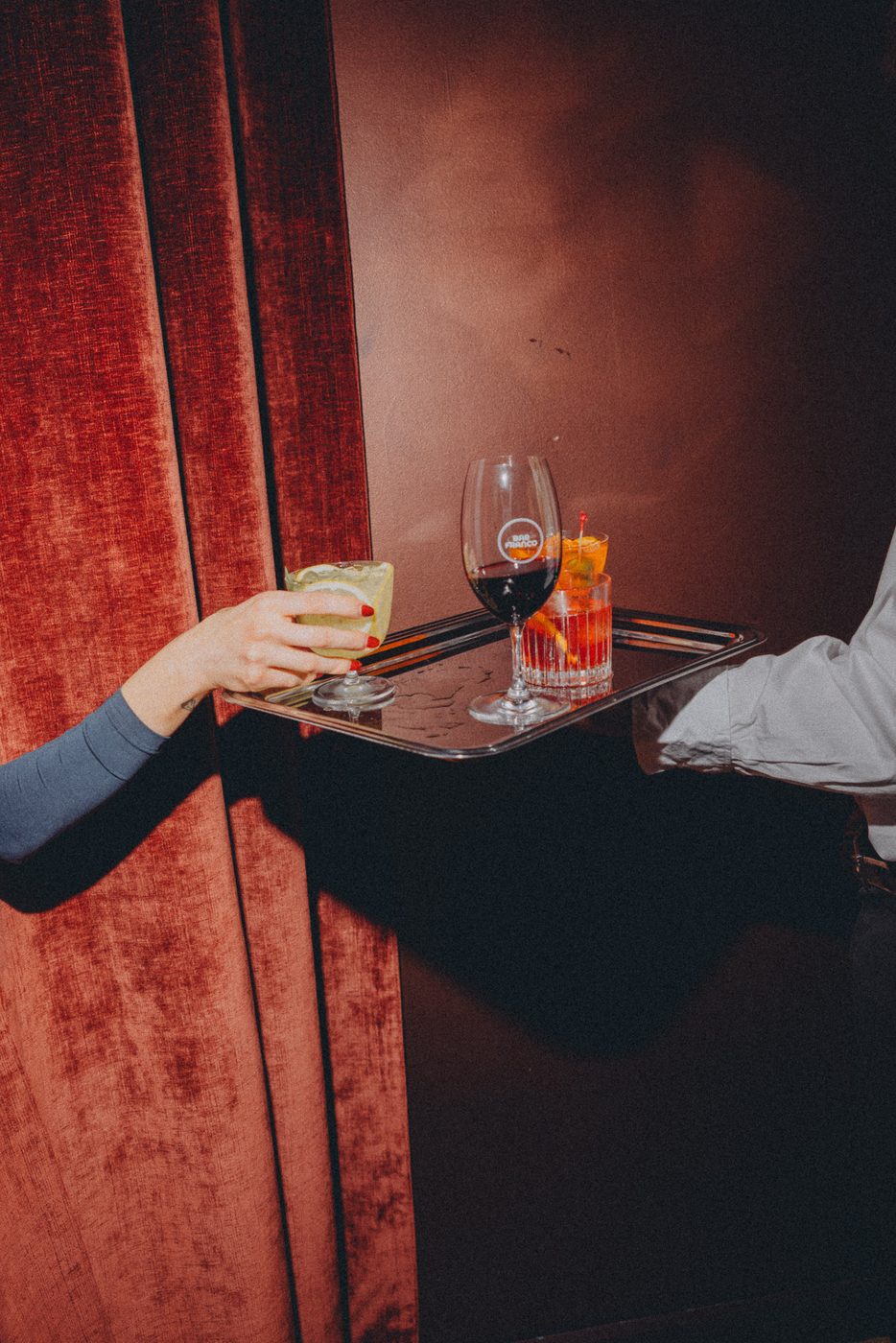 Cocktails served on a silver tray by the velvet curtains in the bar